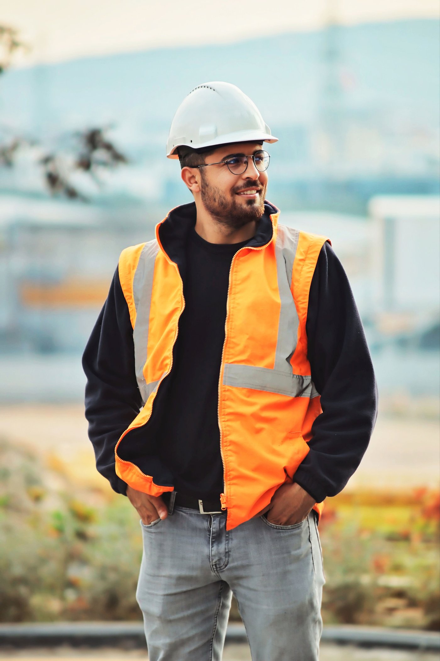 Profesional sonriente con casco y chaleco de obra